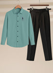 Teal shirt with logo and black pants