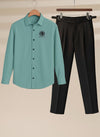 Teal shirt with black logo and black pants
